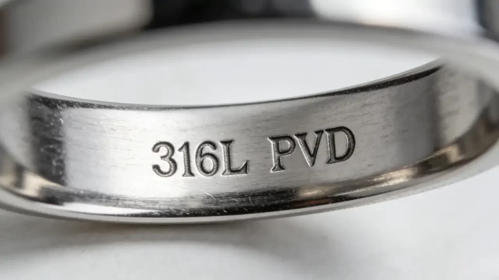 Close-up macro shot of the inner band of a ring, clearly showing the "316L PVD" steel stamp marking.
